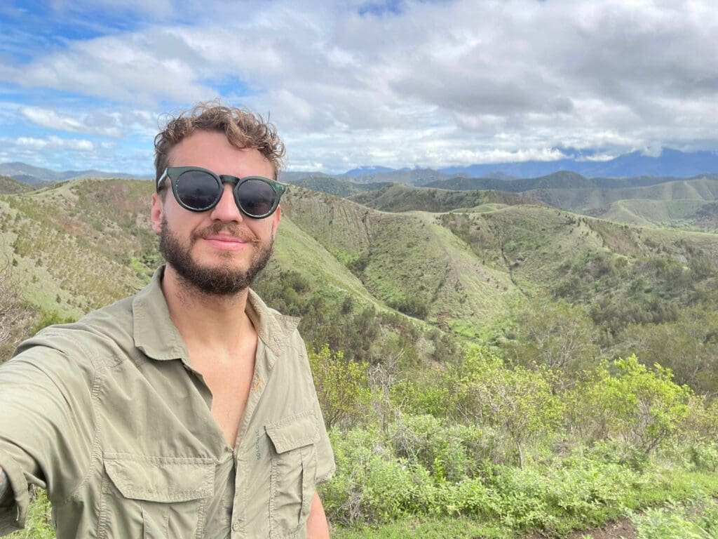Expedition team member's selfie in front of green hills on Grande Terre